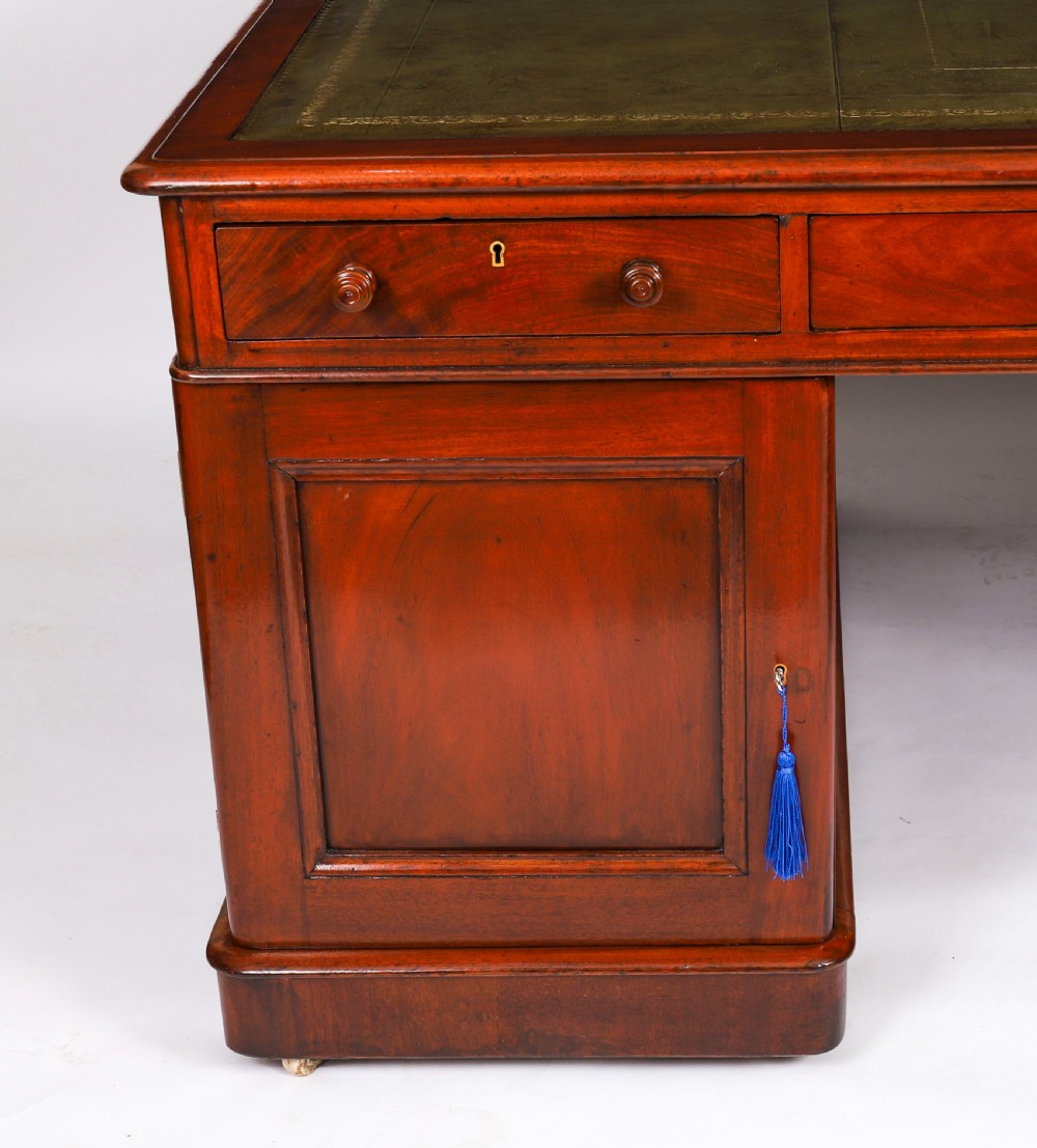A Victorian flame mahogany partners pedestal desk fitted with a green leather inset top and wooden knob drawer pulls. View XIV