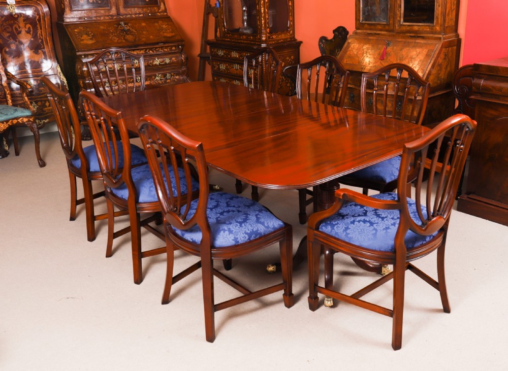 A George III Regency period mahogany twin pillar dining table featuring reeded edge detail and tripod pedestal legs with brass castors. View II