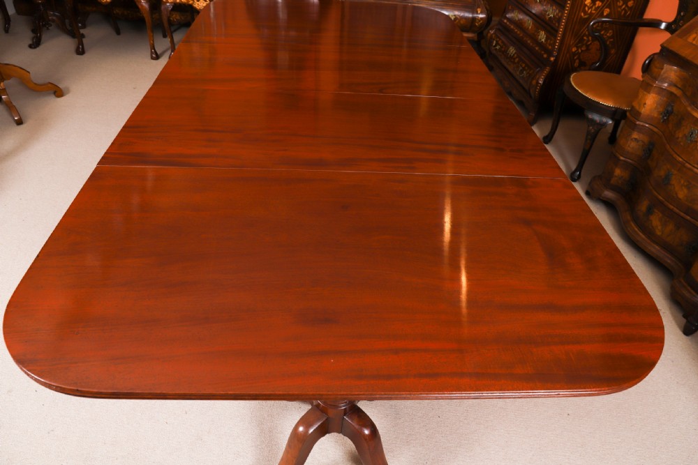 A George III Regency period mahogany twin pillar dining table featuring reeded edge detail and tripod pedestal legs with brass castors. View VIII