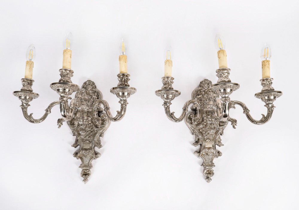 A matching set of four silver-plated three-arm French Rococo style wall appliques featuring ornate foliage scrollwork and candle-shaped bulb holders. View II