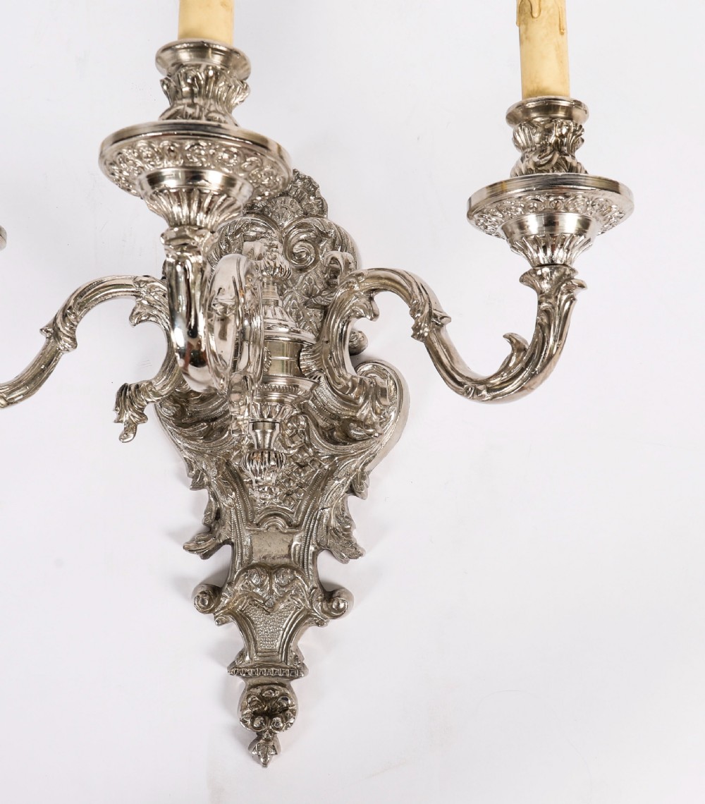 A matching set of four silver-plated three-arm French Rococo style wall appliques featuring ornate foliage scrollwork and candle-shaped bulb holders. View XI