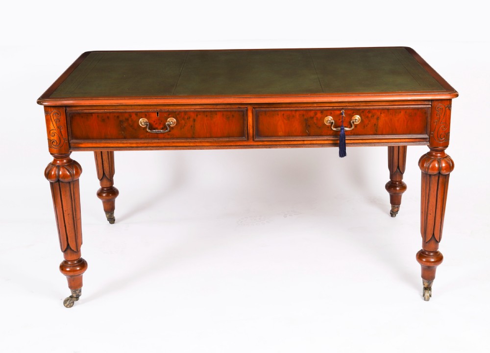 Nineteenth-century Victorian mahogany writing table featuring a green leather inset top, two drawers with brass drop handles, and carved turned legs on brass castors. View II