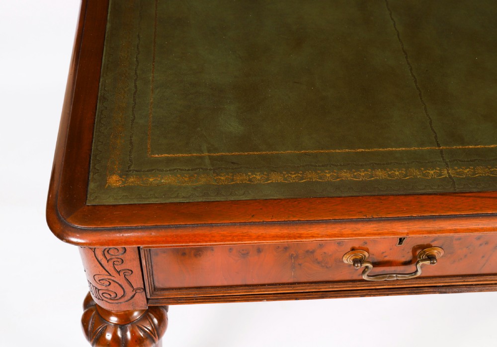Nineteenth-century Victorian mahogany writing table featuring a green leather inset top, two drawers with brass drop handles, and carved turned legs on brass castors. View IV