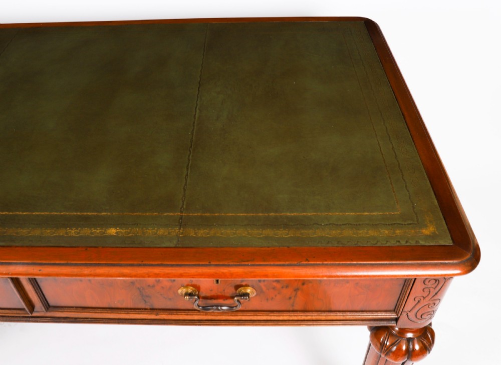 Nineteenth-century Victorian mahogany writing table featuring a green leather inset top, two drawers with brass drop handles, and carved turned legs on brass castors. View V