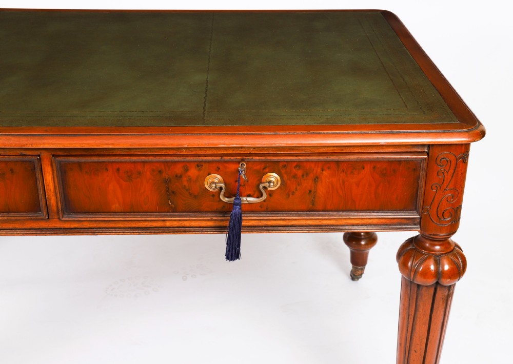 Nineteenth-century Victorian mahogany writing table featuring a green leather inset top, two drawers with brass drop handles, and carved turned legs on brass castors. View VIII
