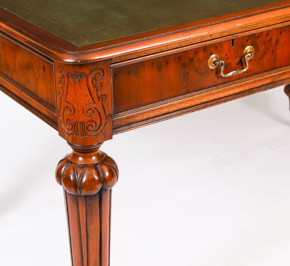 Nineteenth-century Victorian mahogany writing table featuring a green leather inset top, two drawers with brass drop handles, and carved turned legs on brass castors. View IX