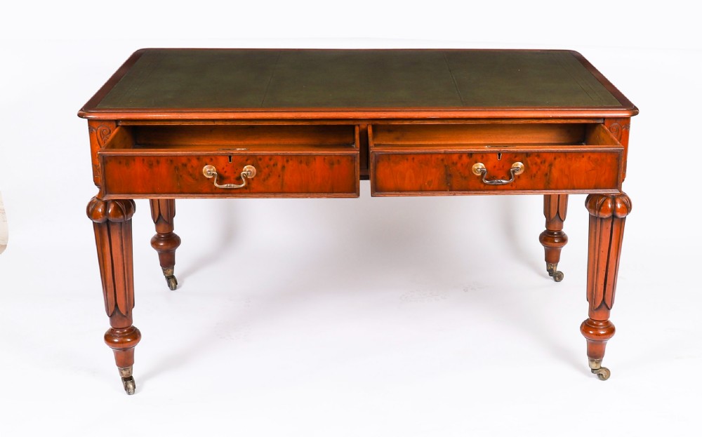 Nineteenth-century Victorian mahogany writing table featuring a green leather inset top, two drawers with brass drop handles, and carved turned legs on brass castors. View XV