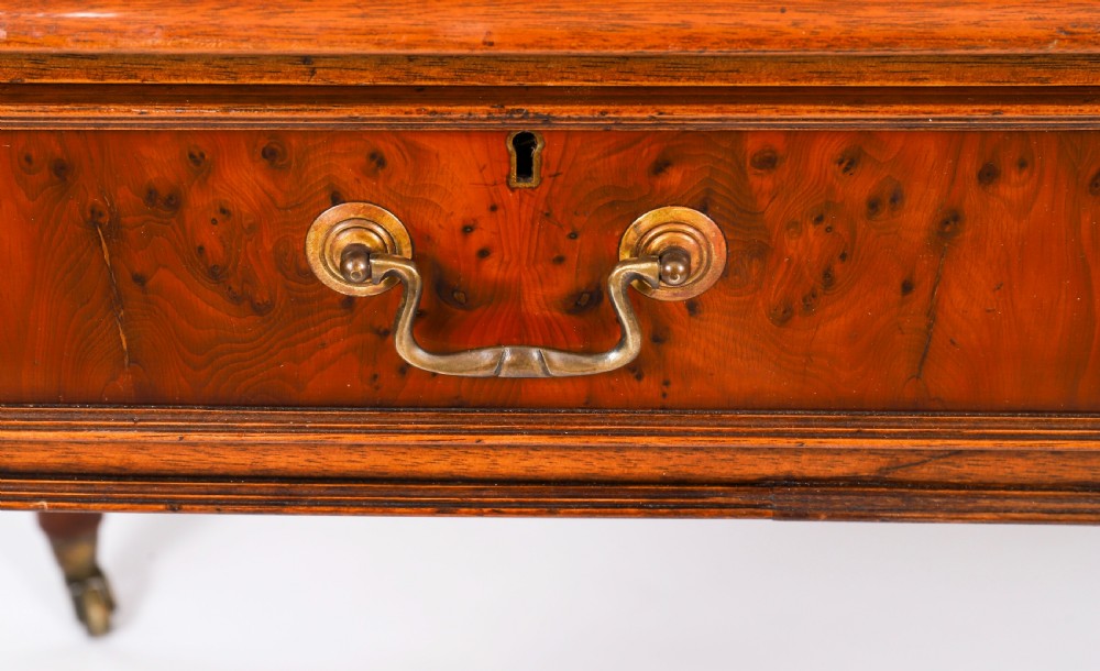 Nineteenth-century Victorian mahogany writing table featuring a green leather inset top, two drawers with brass drop handles, and carved turned legs on brass castors. View XVIII
