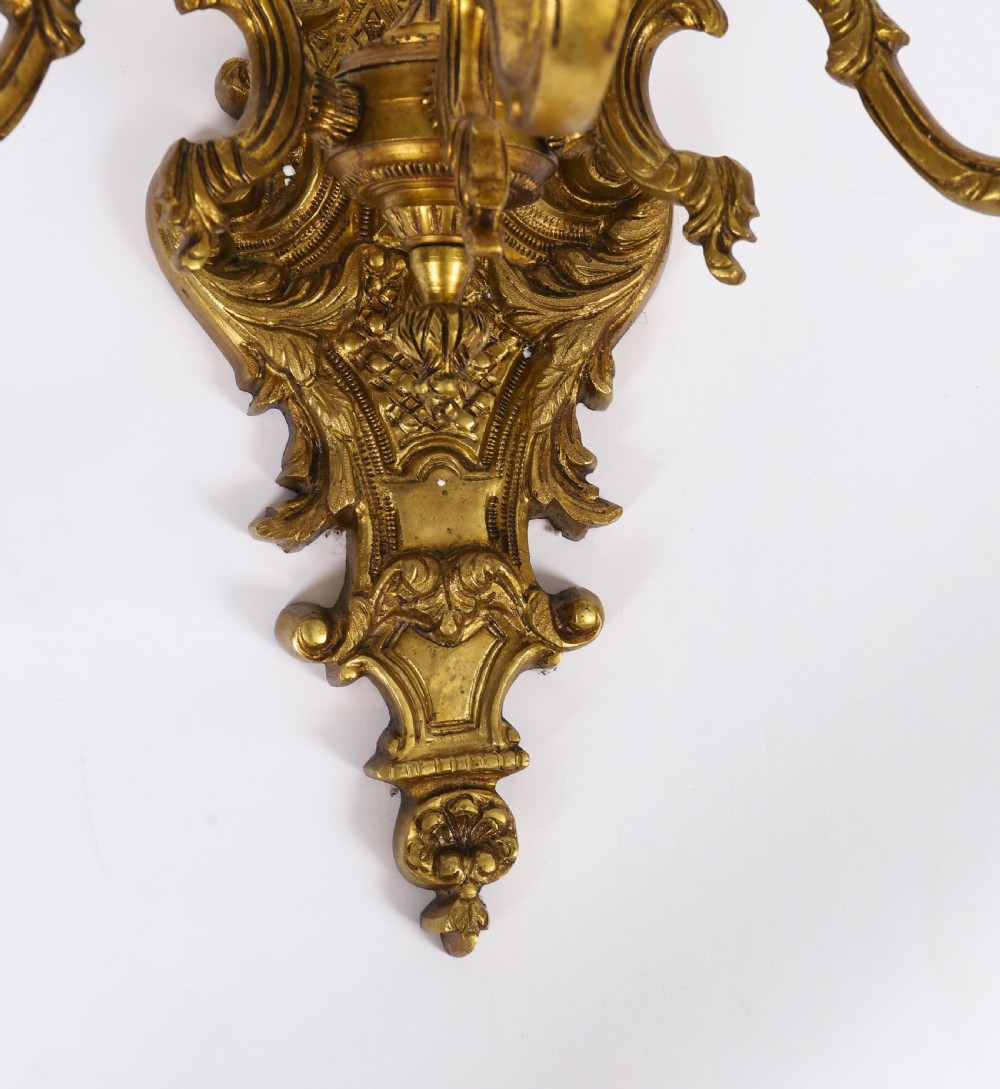 A set of eight French gilt bronze three-arm wall appliques featuring ornate foliate castings and candle-style fittings. View XIII
