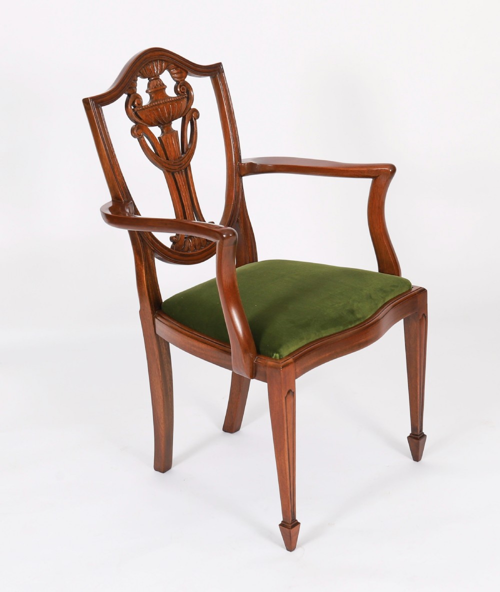 A set of eight Edwardian mahogany dining chairs featuring carved shield backs with urn splats and green velvet upholstered seats. View IV