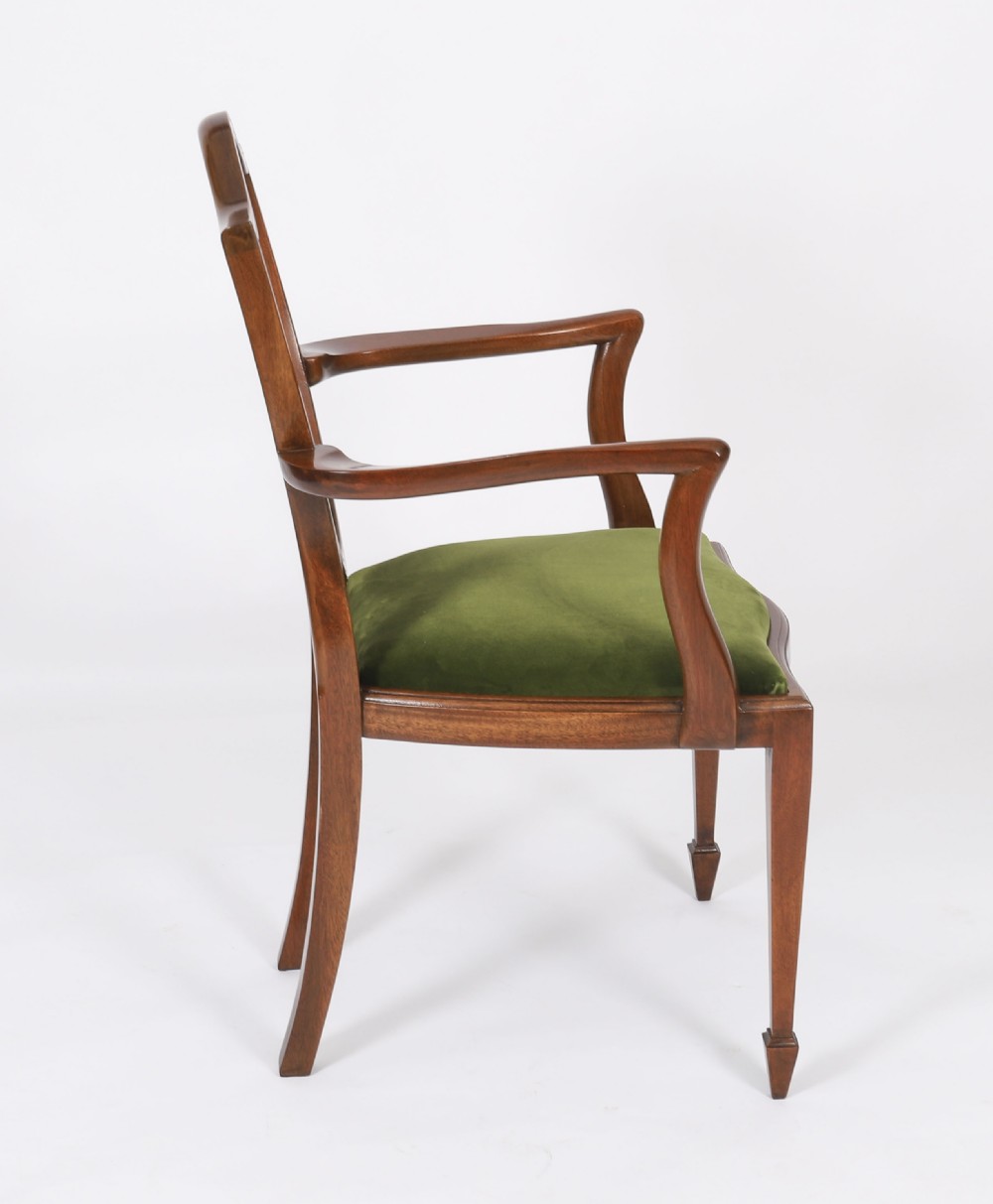 A set of eight Edwardian mahogany dining chairs featuring carved shield backs with urn splats and green velvet upholstered seats. View V