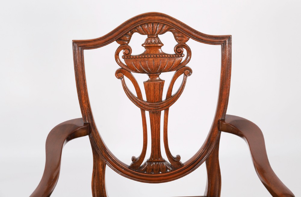 A set of eight Edwardian mahogany dining chairs featuring carved shield backs with urn splats and green velvet upholstered seats. View VII