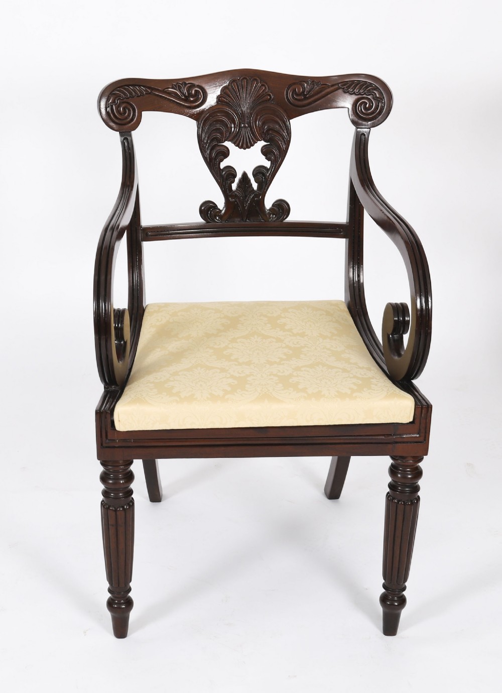 A set of twelve nineteenth-century Irish Regency mahogany dining chairs with carved shell back crests and cream upholstered seats. View X