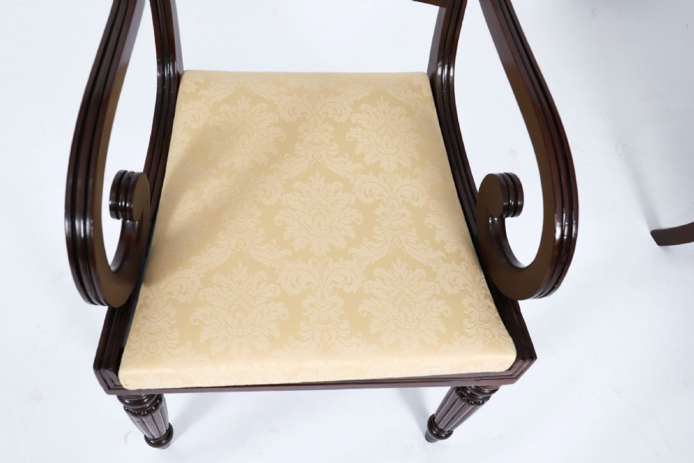 A set of twelve nineteenth-century Irish Regency mahogany dining chairs with carved shell back crests and cream upholstered seats. View XVI
