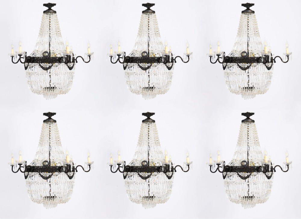 A set of six Louis XVI Revival cut crystal tent and bag chandeliers featuring dark metal frames and perimeter candle sockets on scrolling arms.