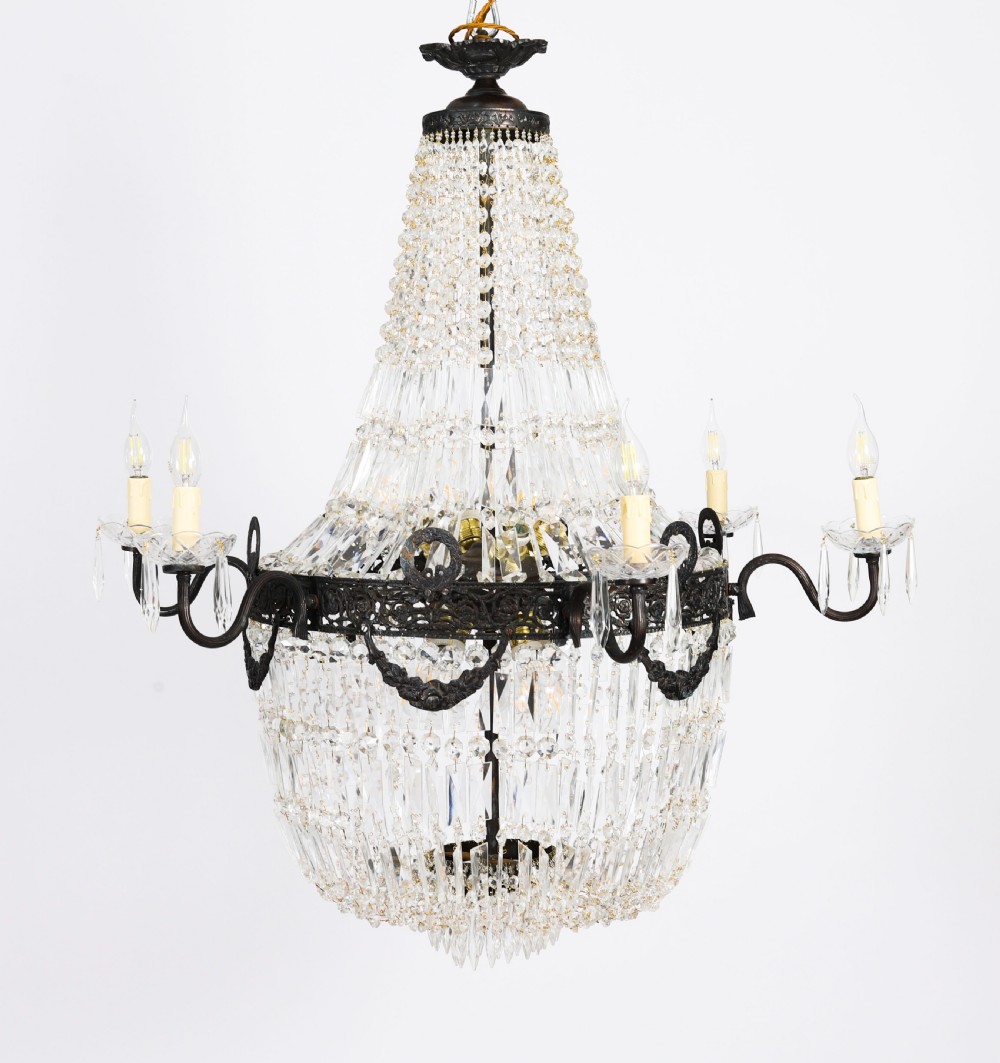 A set of six Louis XVI Revival cut crystal tent and bag chandeliers featuring dark metal frames and perimeter candle sockets on scrolling arms. View XVIII