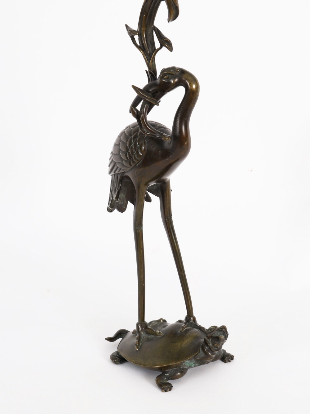 A pair of 19th-century Japanese dark bronze pricket candlesticks formed as cranes standing on tortoises holding lotus stems in their beaks. View IV