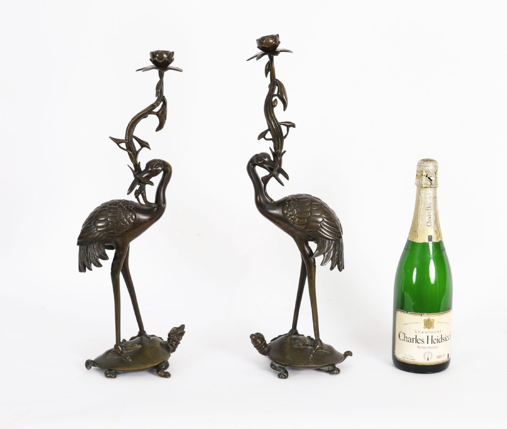 A pair of 19th-century Japanese dark bronze pricket candlesticks formed as cranes standing on tortoises holding lotus stems in their beaks. View XIX