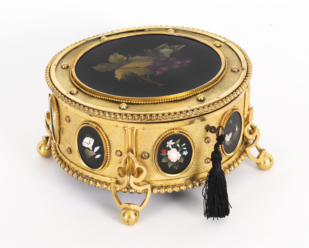 A circular 19th-century ormolu jewellery casket featuring fine Pietra Dura floral and fruit stone inlays set into gilt bronze with a key and tassel.