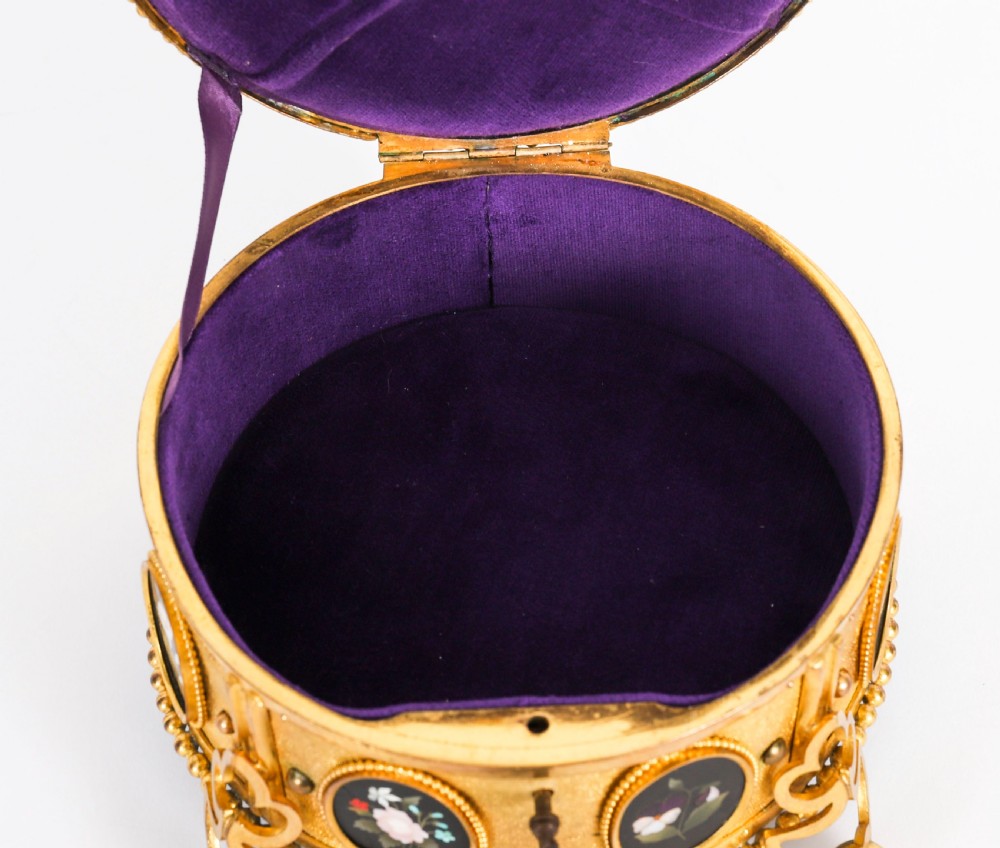A circular 19th-century ormolu jewellery casket featuring fine Pietra Dura floral and fruit stone inlays set into gilt bronze with a key and tassel. View V