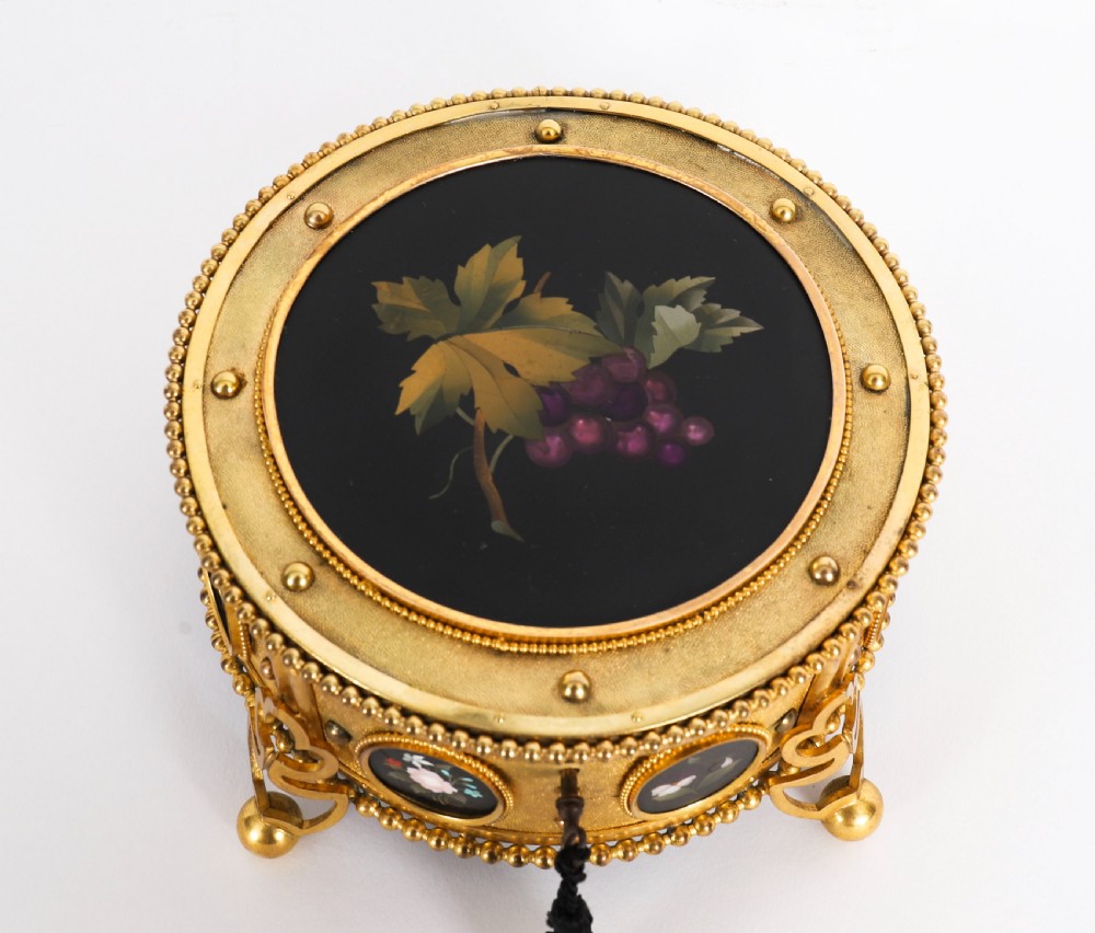 A circular 19th-century ormolu jewellery casket featuring fine Pietra Dura floral and fruit stone inlays set into gilt bronze with a key and tassel. View IX