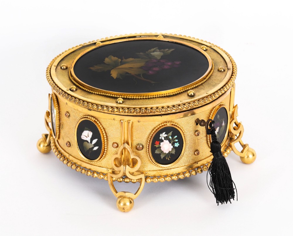 A circular 19th-century ormolu jewellery casket featuring fine Pietra Dura floral and fruit stone inlays set into gilt bronze with a key and tassel. View X