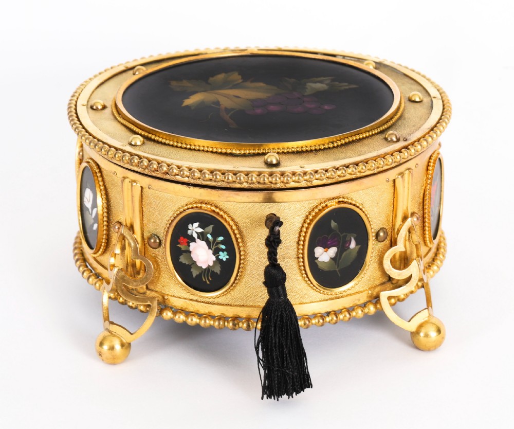A circular 19th-century ormolu jewellery casket featuring fine Pietra Dura floral and fruit stone inlays set into gilt bronze with a key and tassel. View XV
