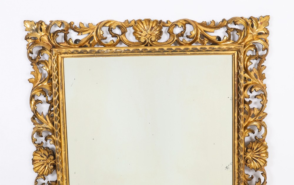A rectangular 19th-century Italian giltwood wall mirror featuring an openwork frame carved with acanthus leaf scrolls and shell motifs. View II