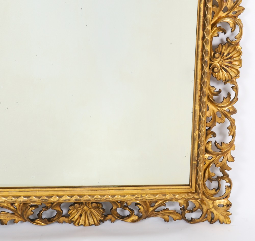 A rectangular 19th-century Italian giltwood wall mirror featuring an openwork frame carved with acanthus leaf scrolls and shell motifs. View IV