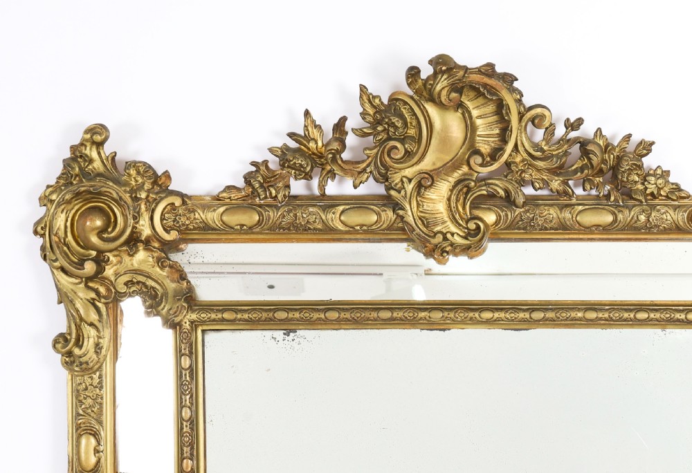 An antique French Louis Revival giltwood cushion overmantel mirror featuring a carved cresting, beaded inner frame, and marginal glass borders. View IV