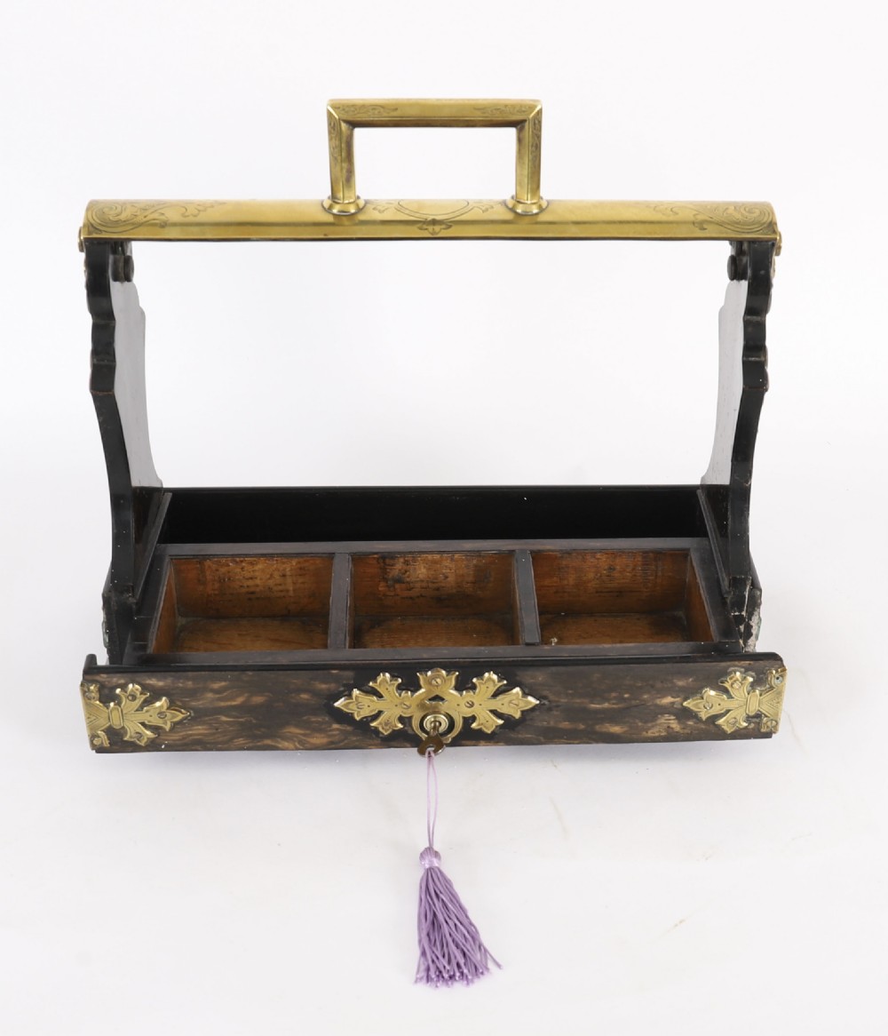 A Victorian coromandel wood tantalus with pierced brass corner mounts and top handle containing three cut crystal decanters with matching stoppers. View V