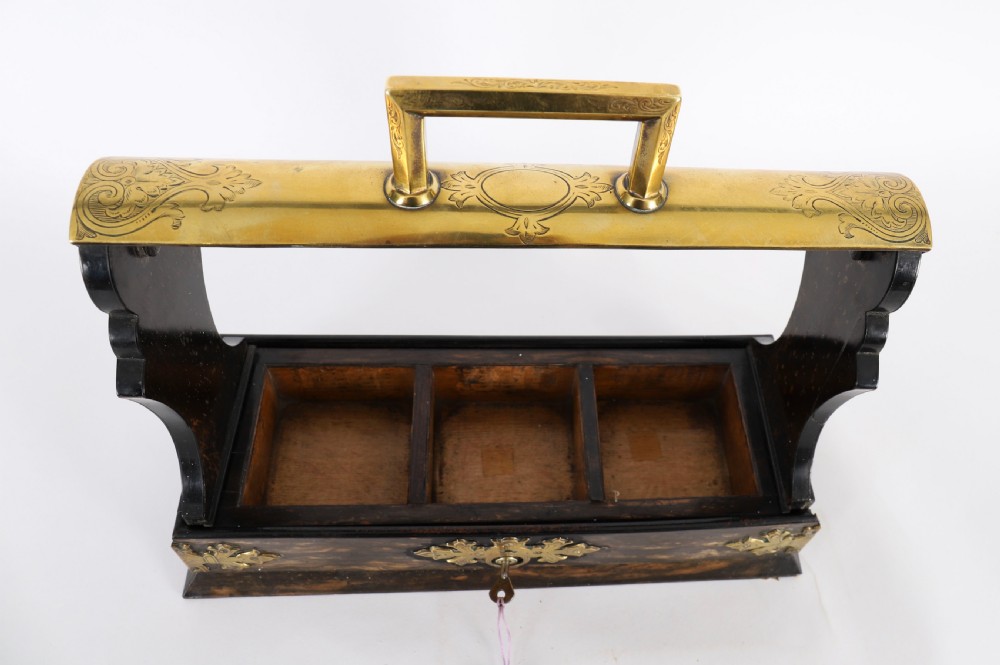 A Victorian coromandel wood tantalus with pierced brass corner mounts and top handle containing three cut crystal decanters with matching stoppers. View VII