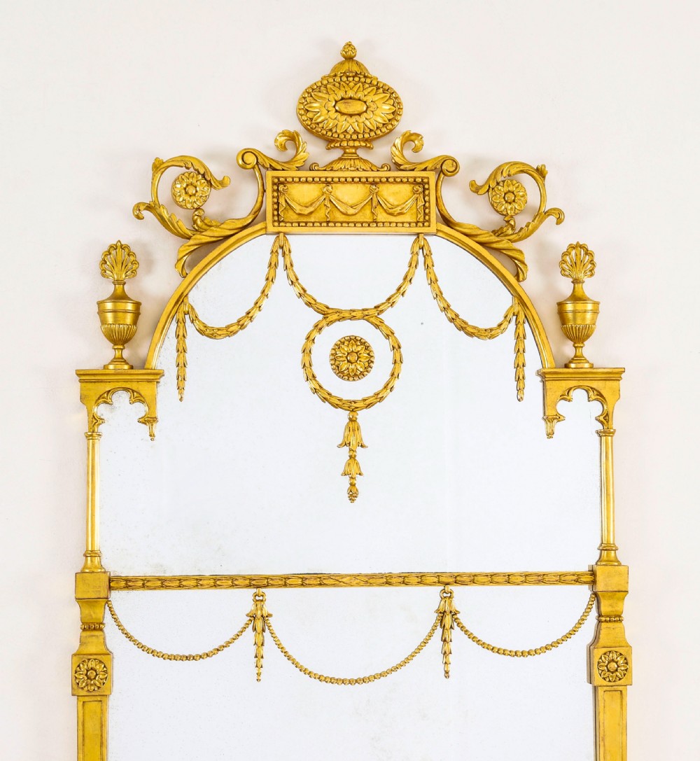 A matching pair of tall 19th-century Neoclassical giltwood pier mirrors decorated with urn crests, draped swags, and rosette motifs. View III