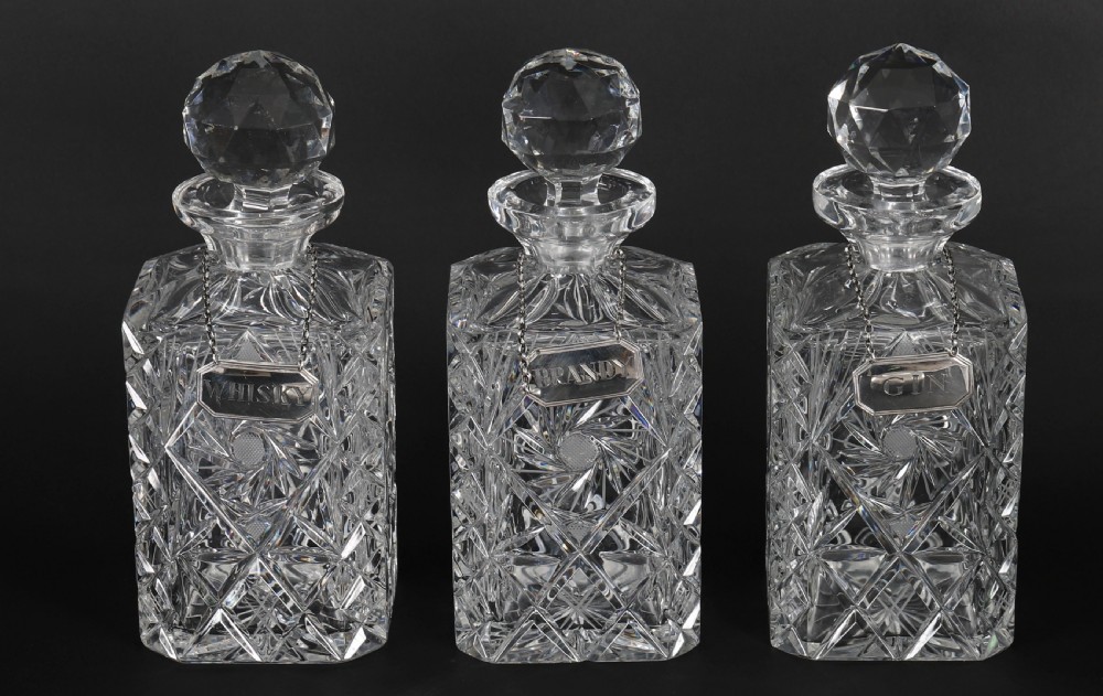 An Edwardian Betjemanns coromandel wood tantalus with hallmarked silver mounts holding three cut-crystal decanters. View VII