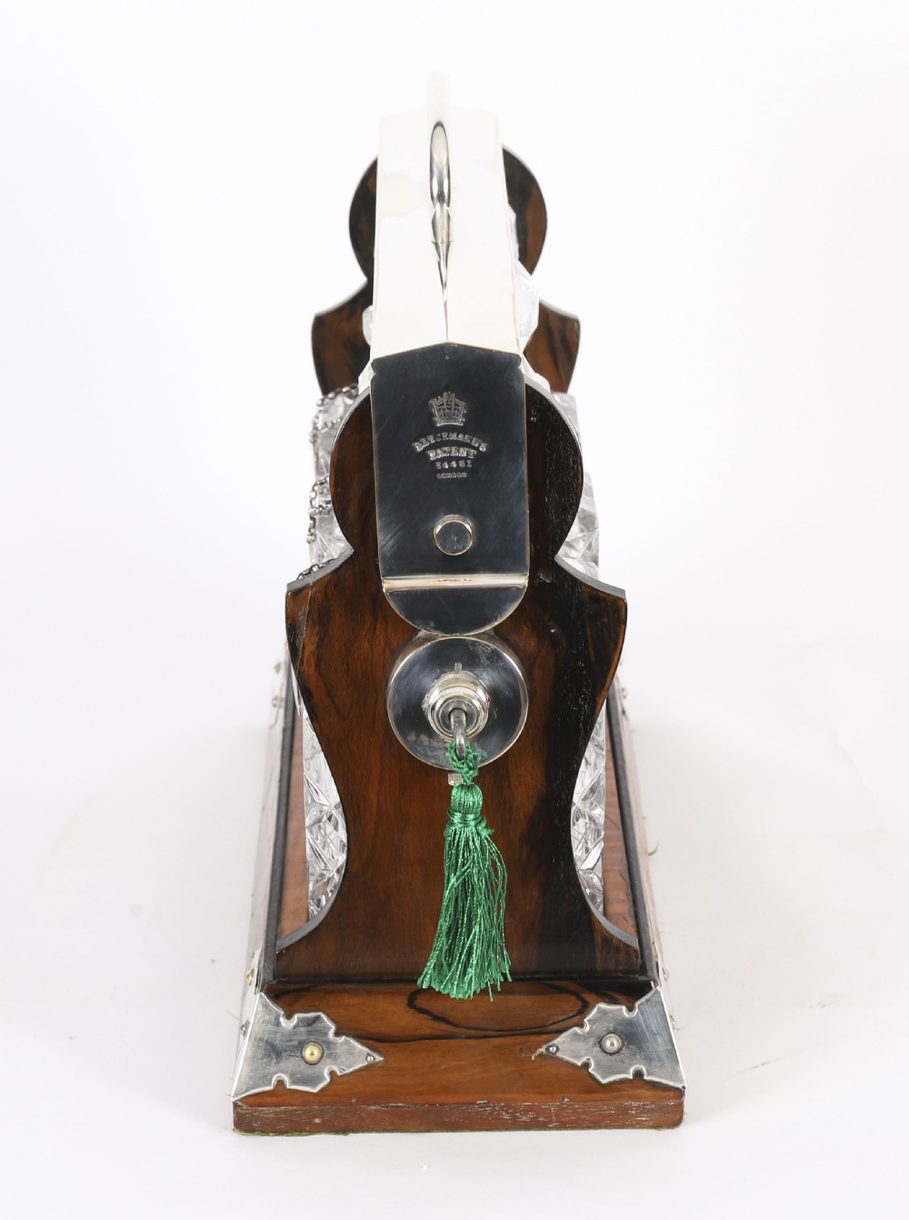 An Edwardian Betjemanns coromandel wood tantalus with hallmarked silver mounts holding three cut-crystal decanters. View XI