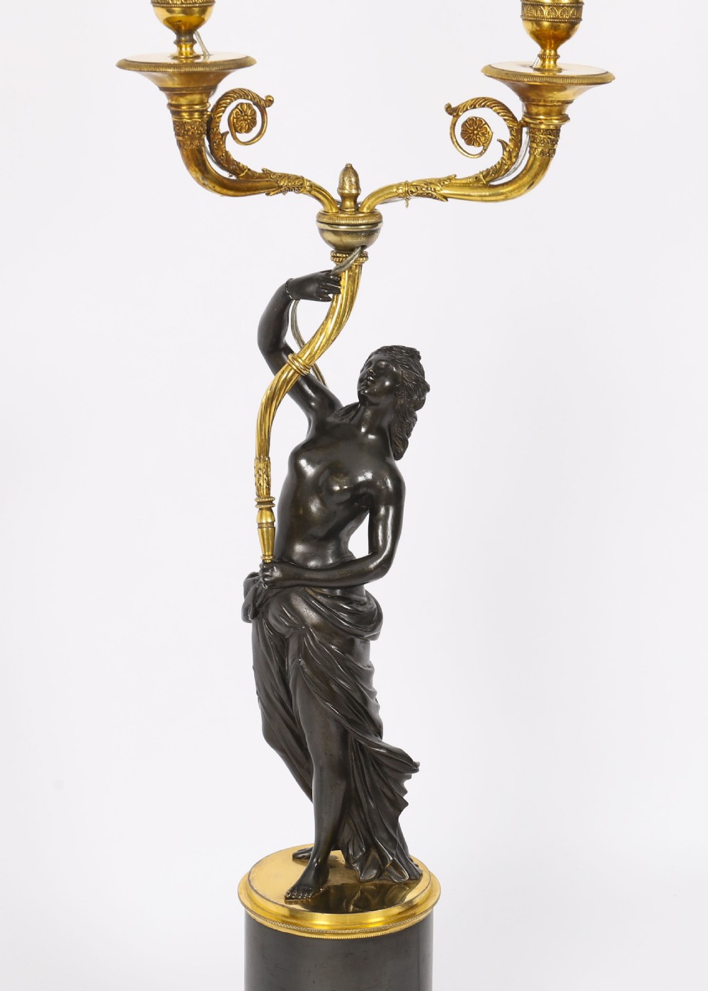 A pair of 19th-century French patinated bronze and gilt bronze two-light candelabra featuring classical draped female figures on cylindrical bases. View III