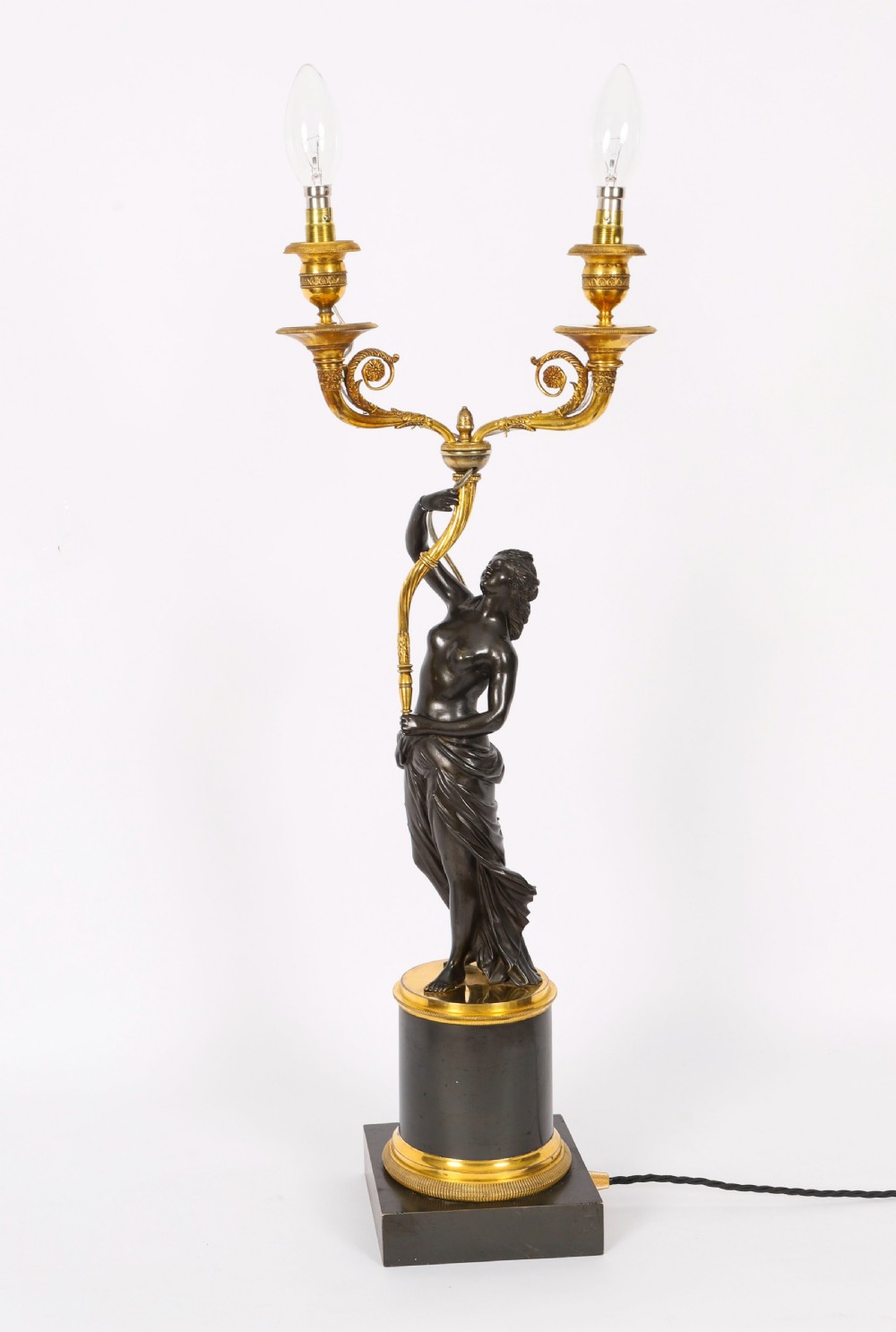 A pair of 19th-century French patinated bronze and gilt bronze two-light candelabra featuring classical draped female figures on cylindrical bases. View VI