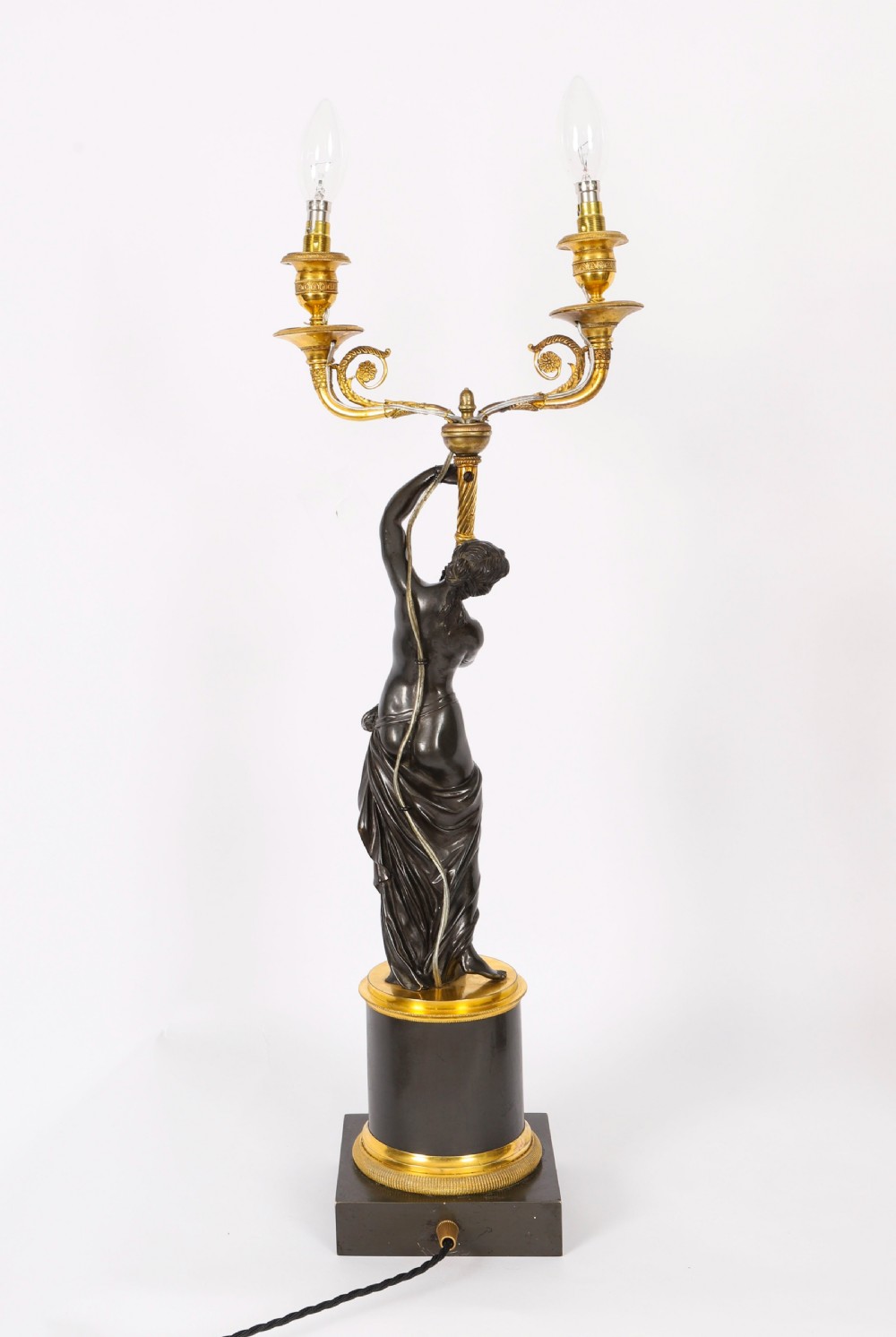 A pair of 19th-century French patinated bronze and gilt bronze two-light candelabra featuring classical draped female figures on cylindrical bases. View VIII