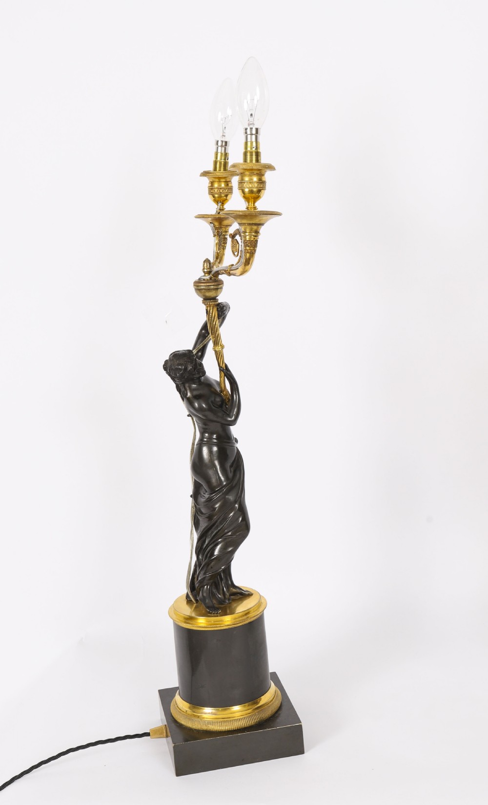 A pair of 19th-century French patinated bronze and gilt bronze two-light candelabra featuring classical draped female figures on cylindrical bases. View IX