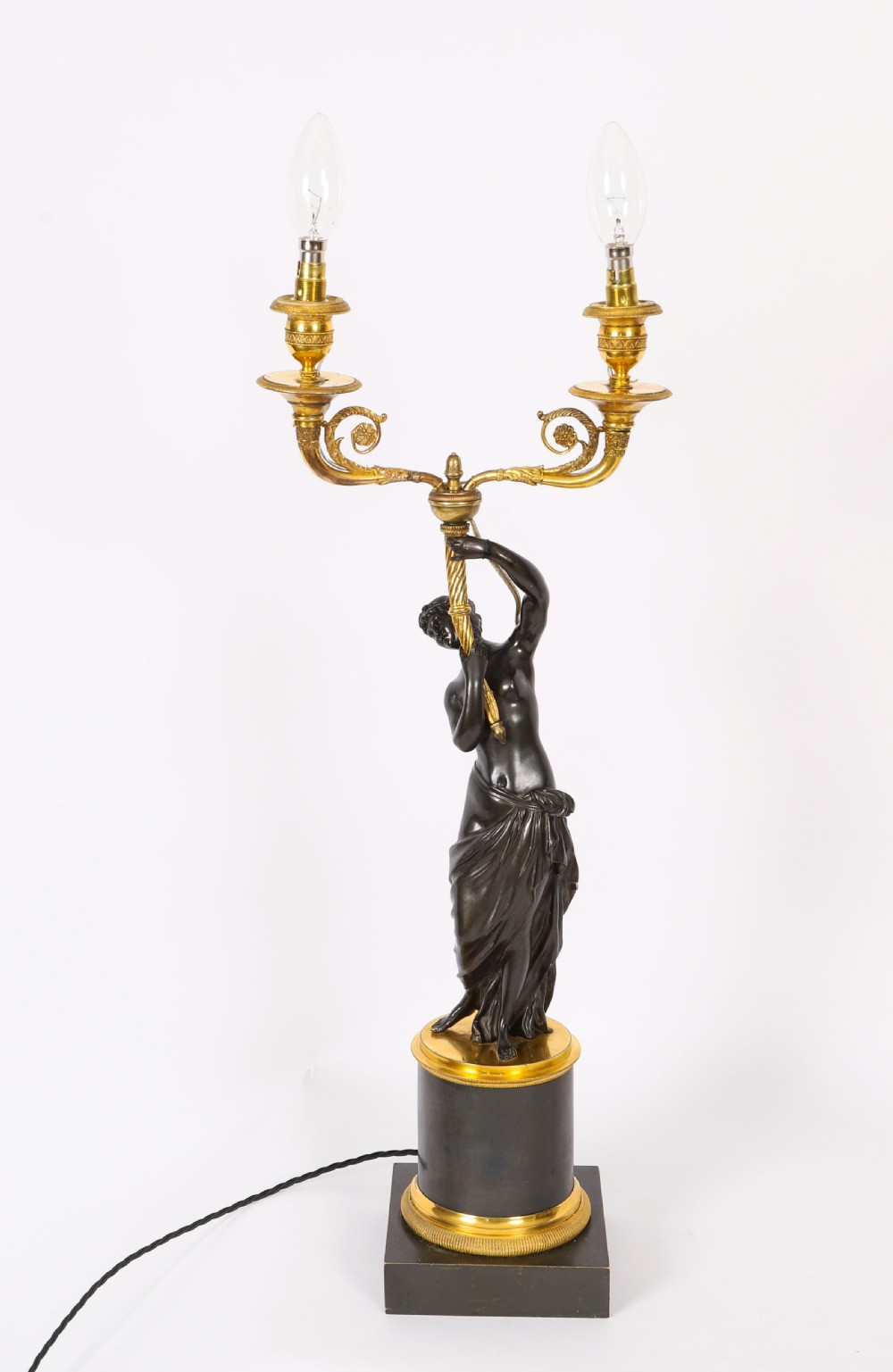 A pair of 19th-century French patinated bronze and gilt bronze two-light candelabra featuring classical draped female figures on cylindrical bases. View XVII