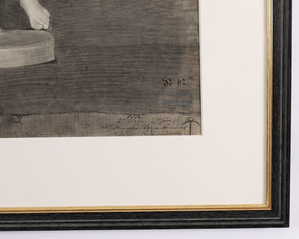 A monochrome charcoal drawing depicting a classical male nude sculpture in a black and gold frame with a cream mount. View VI