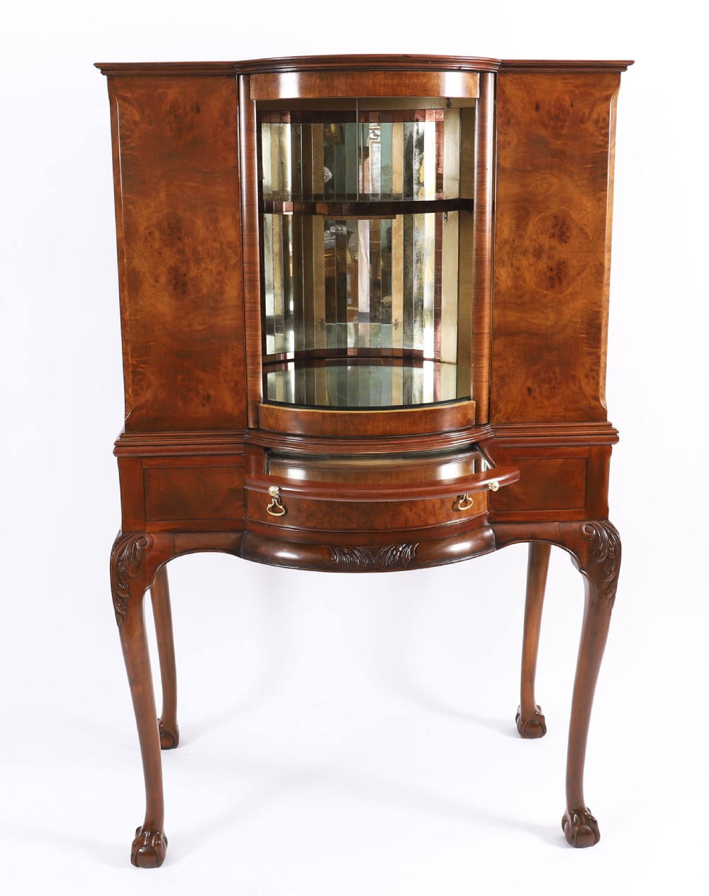 A high-standing burr walnut revolving cocktail cabinet raised on cabriole legs with carved knees and claw-and-ball feet. View VII