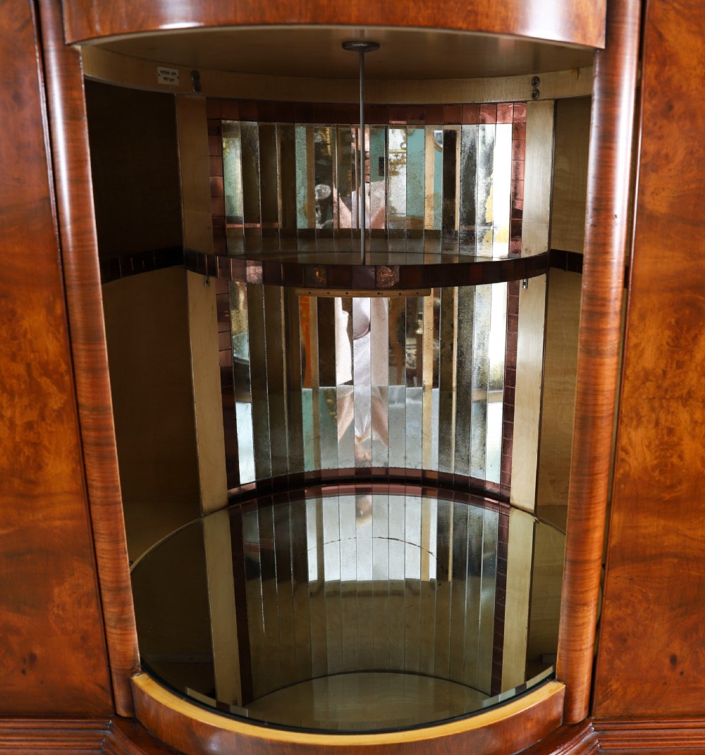 A high-standing burr walnut revolving cocktail cabinet raised on cabriole legs with carved knees and claw-and-ball feet. View XII