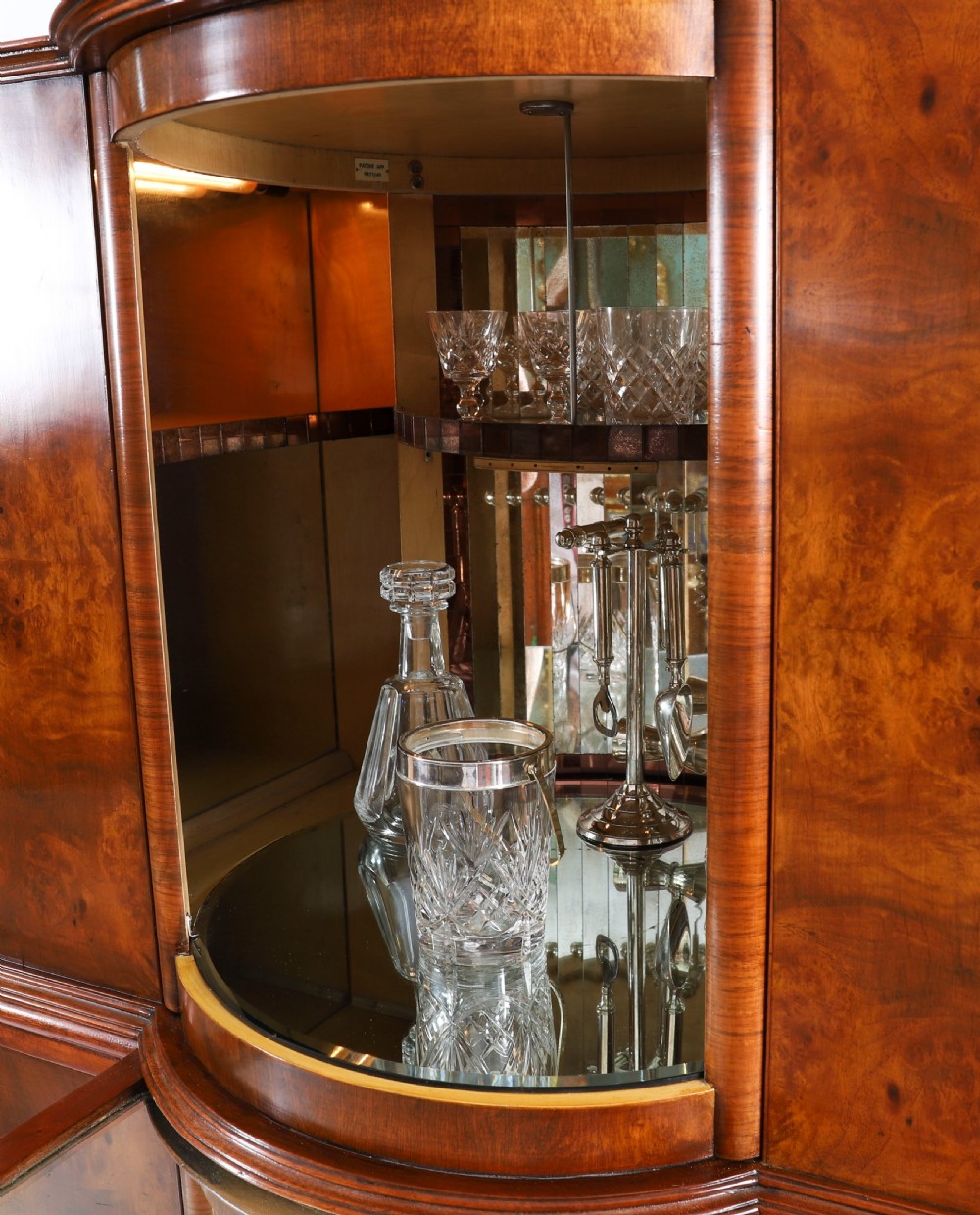 A high-standing burr walnut revolving cocktail cabinet raised on cabriole legs with carved knees and claw-and-ball feet. View XV