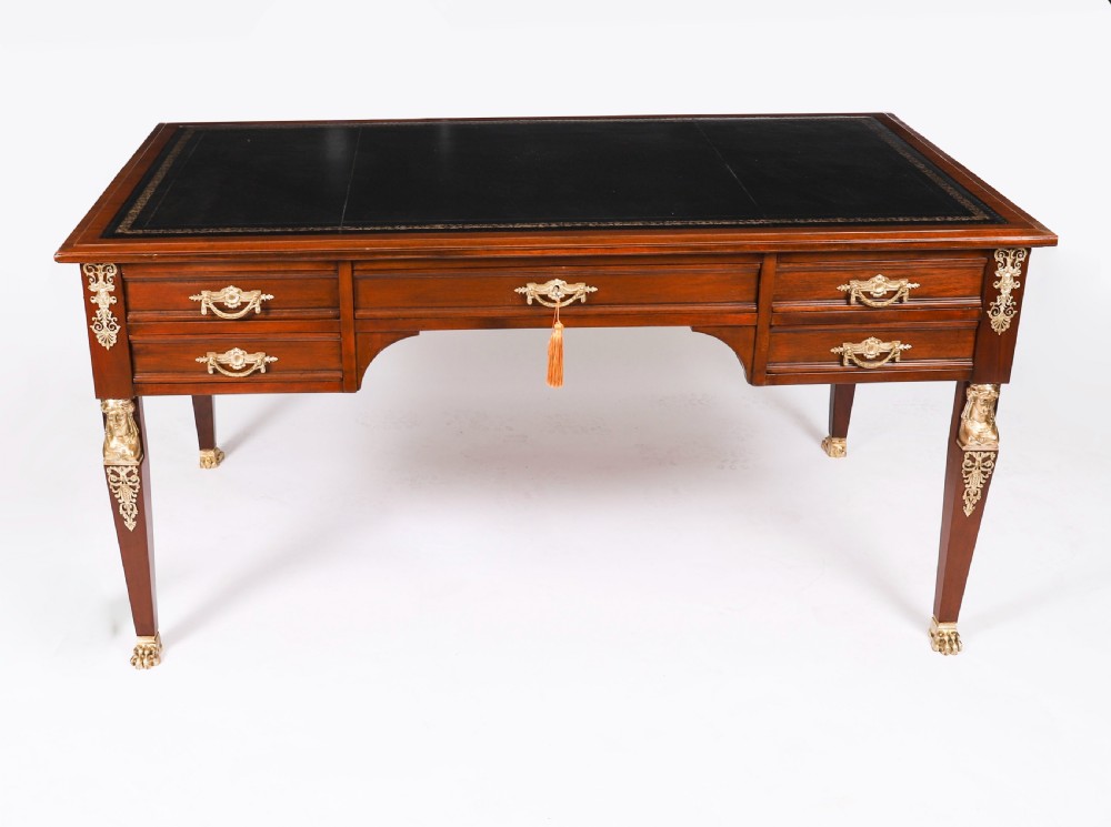 A nineteenth-century French Empire style mahogany bureau plat featuring gilt bronze ormolu mounts, tapered legs, five drawers, and a black leather writing surface. View II