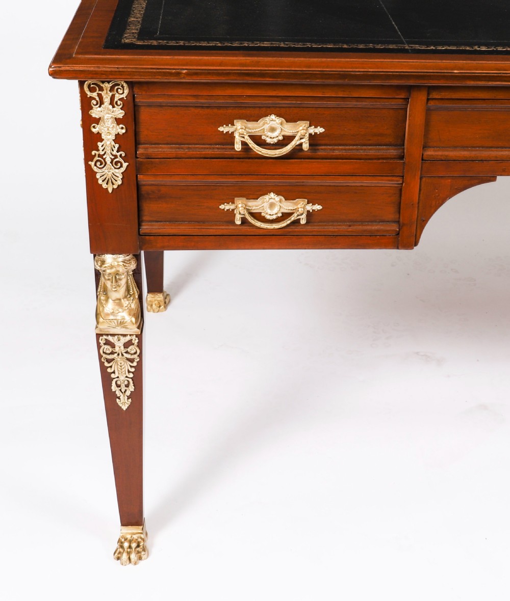 A nineteenth-century French Empire style mahogany bureau plat featuring gilt bronze ormolu mounts, tapered legs, five drawers, and a black leather writing surface. View VI