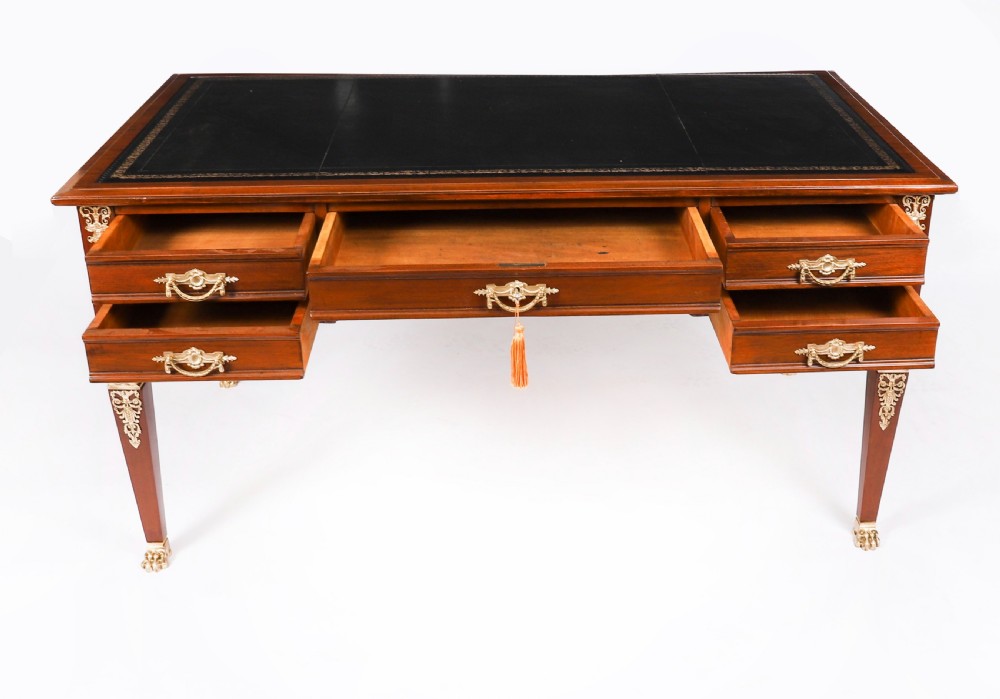 A nineteenth-century French Empire style mahogany bureau plat featuring gilt bronze ormolu mounts, tapered legs, five drawers, and a black leather writing surface. View XI