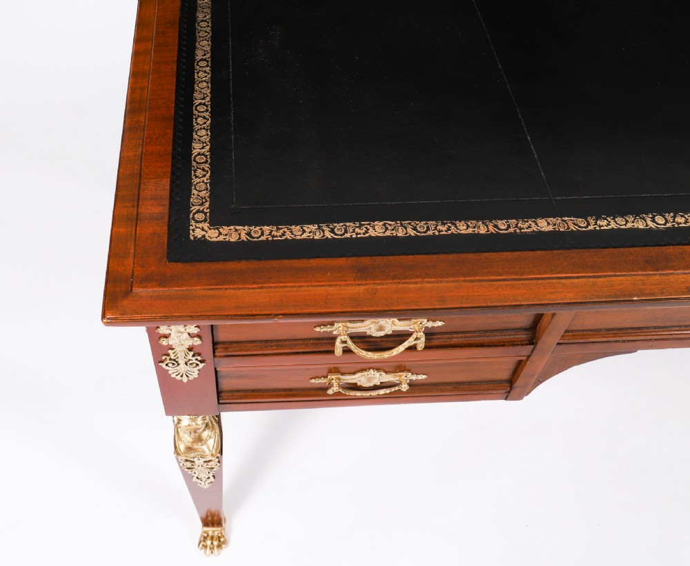 A nineteenth-century French Empire style mahogany bureau plat featuring gilt bronze ormolu mounts, tapered legs, five drawers, and a black leather writing surface. View XIV