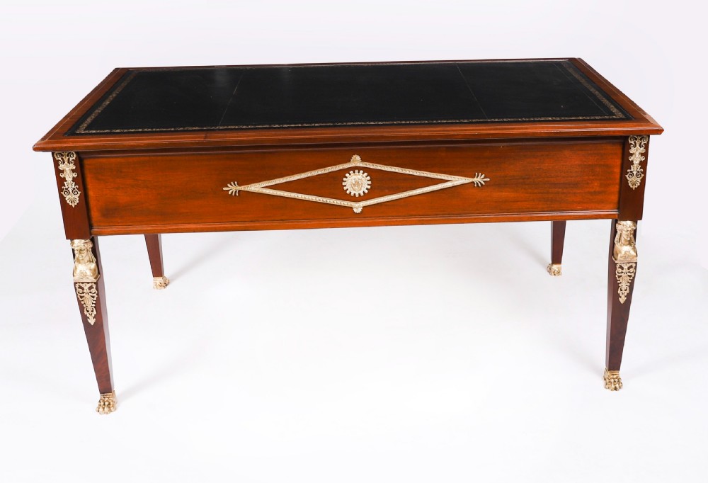 A nineteenth-century French Empire style mahogany bureau plat featuring gilt bronze ormolu mounts, tapered legs, five drawers, and a black leather writing surface. View XVI