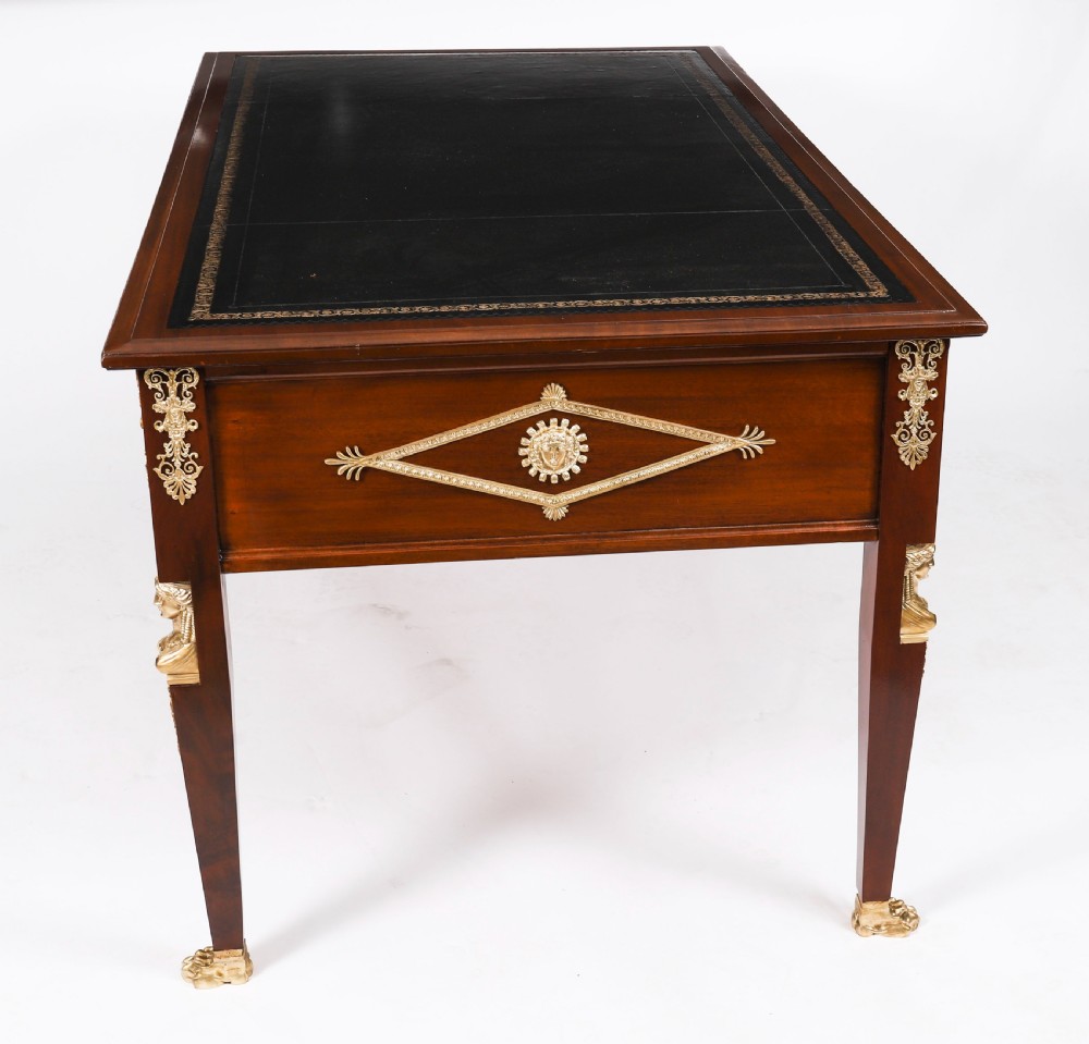 A nineteenth-century French Empire style mahogany bureau plat featuring gilt bronze ormolu mounts, tapered legs, five drawers, and a black leather writing surface. View XVIII